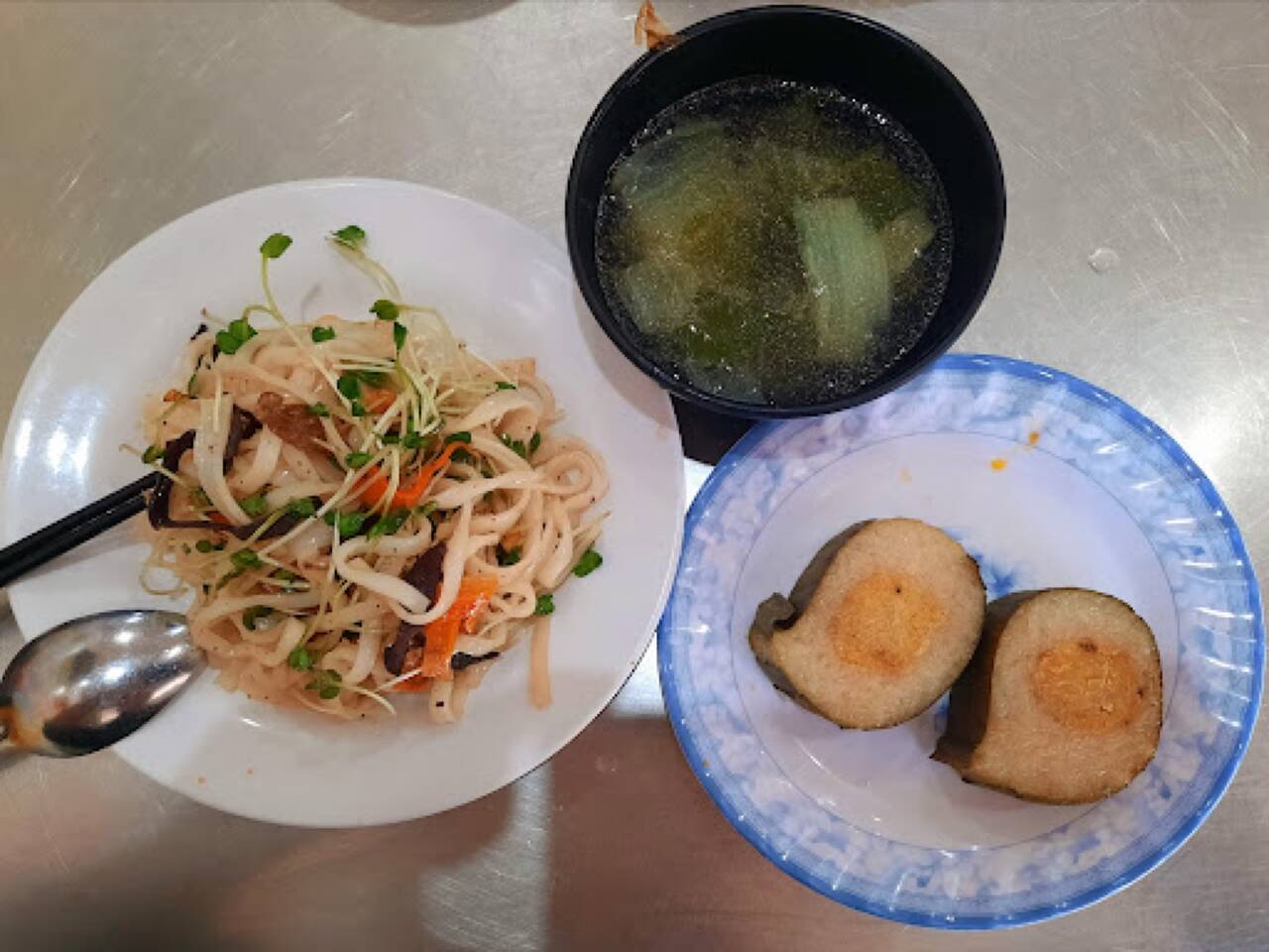 Đĩa mì xào rau, bát canh và chả chay cắt đôi ở quán chay Thanh Thảo