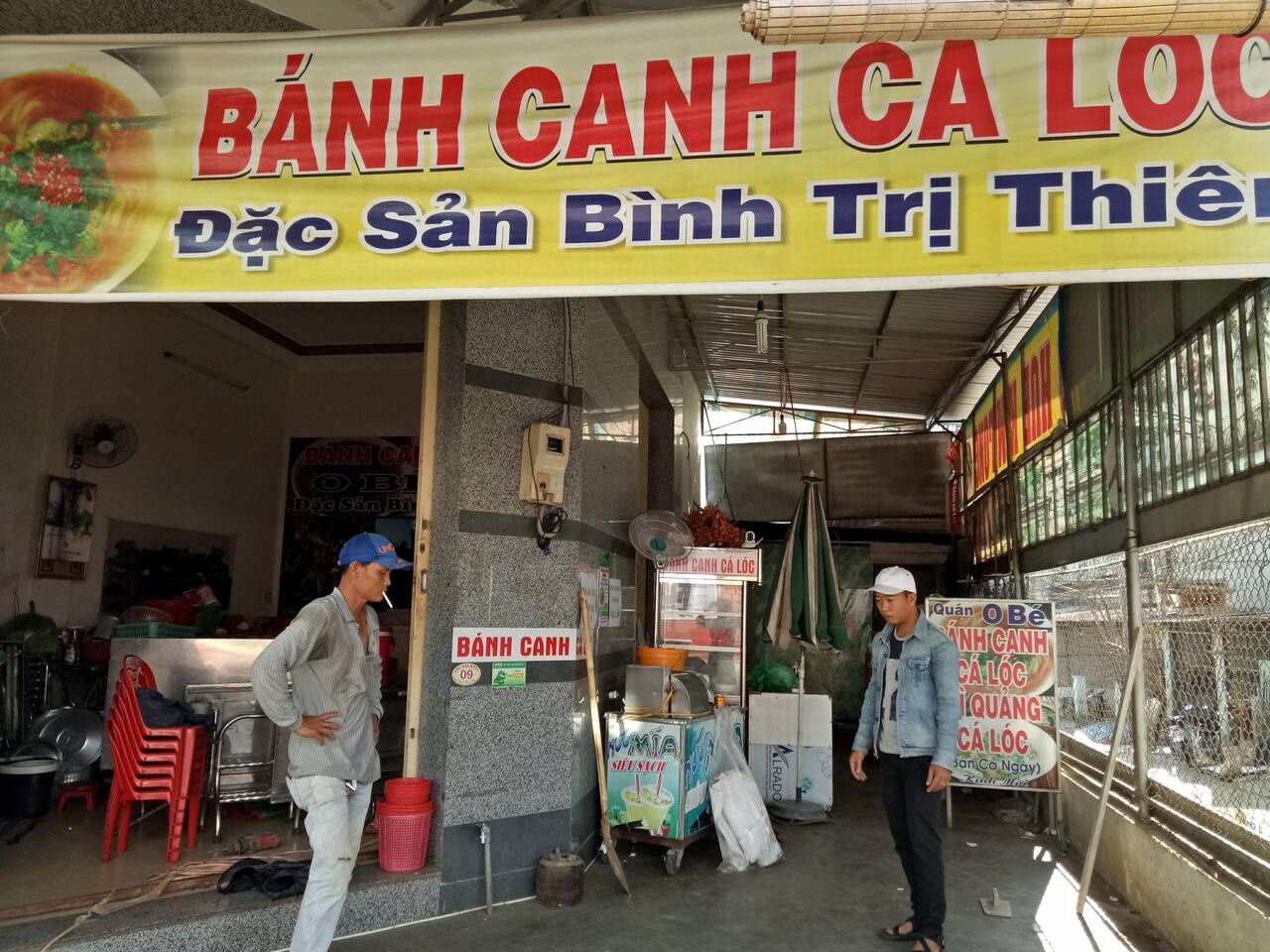 Gian bán bánh canh cá lóc và mì quảng của quán O Bé nhìn từ ngoài vào, biển đỏ vàng phía trên