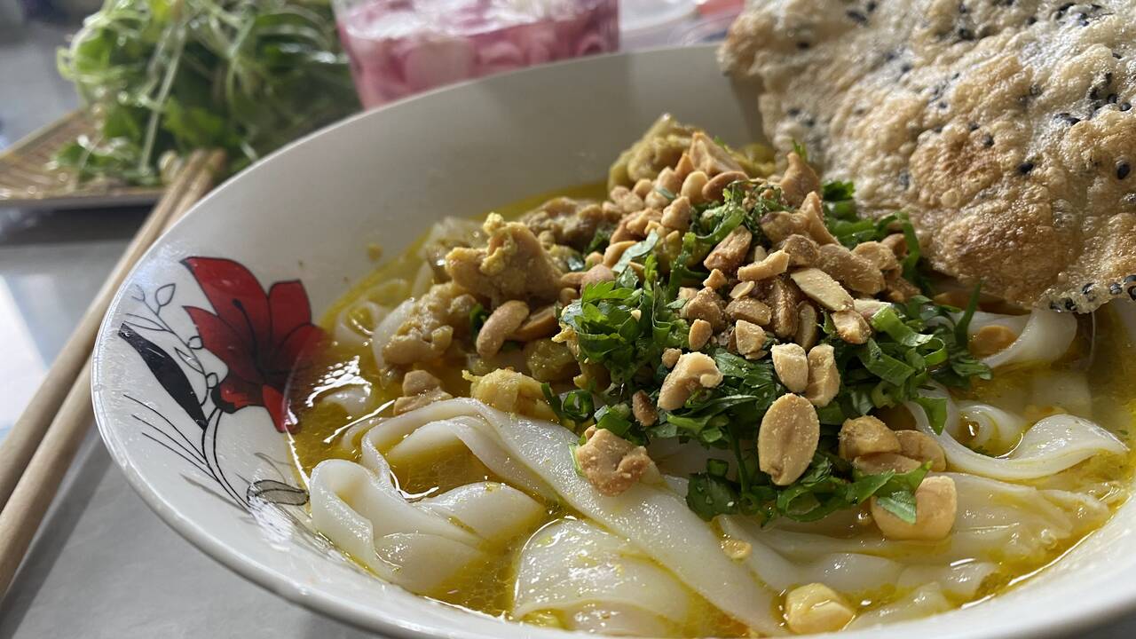 Tô bánh canh sợi to rắc đậu phộng, hành ngò kèm miếng bánh tráng tại quán O Bé