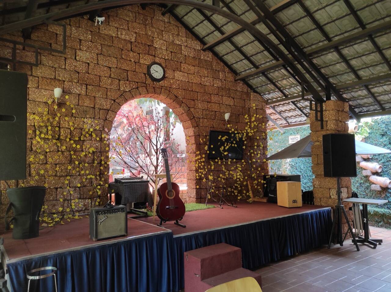 Sân khấu nhỏ có đàn guitar dưới mái gạch nung ở Café Cuội