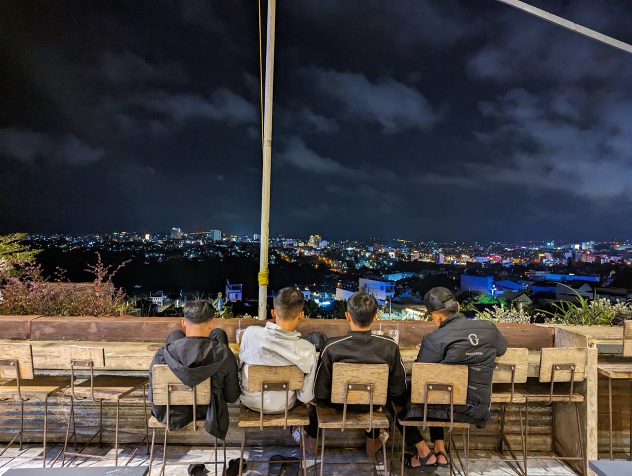 Nhóm bạn ngồi ngắm đèn thành phố Pleiku về đêm từ ban công Hani