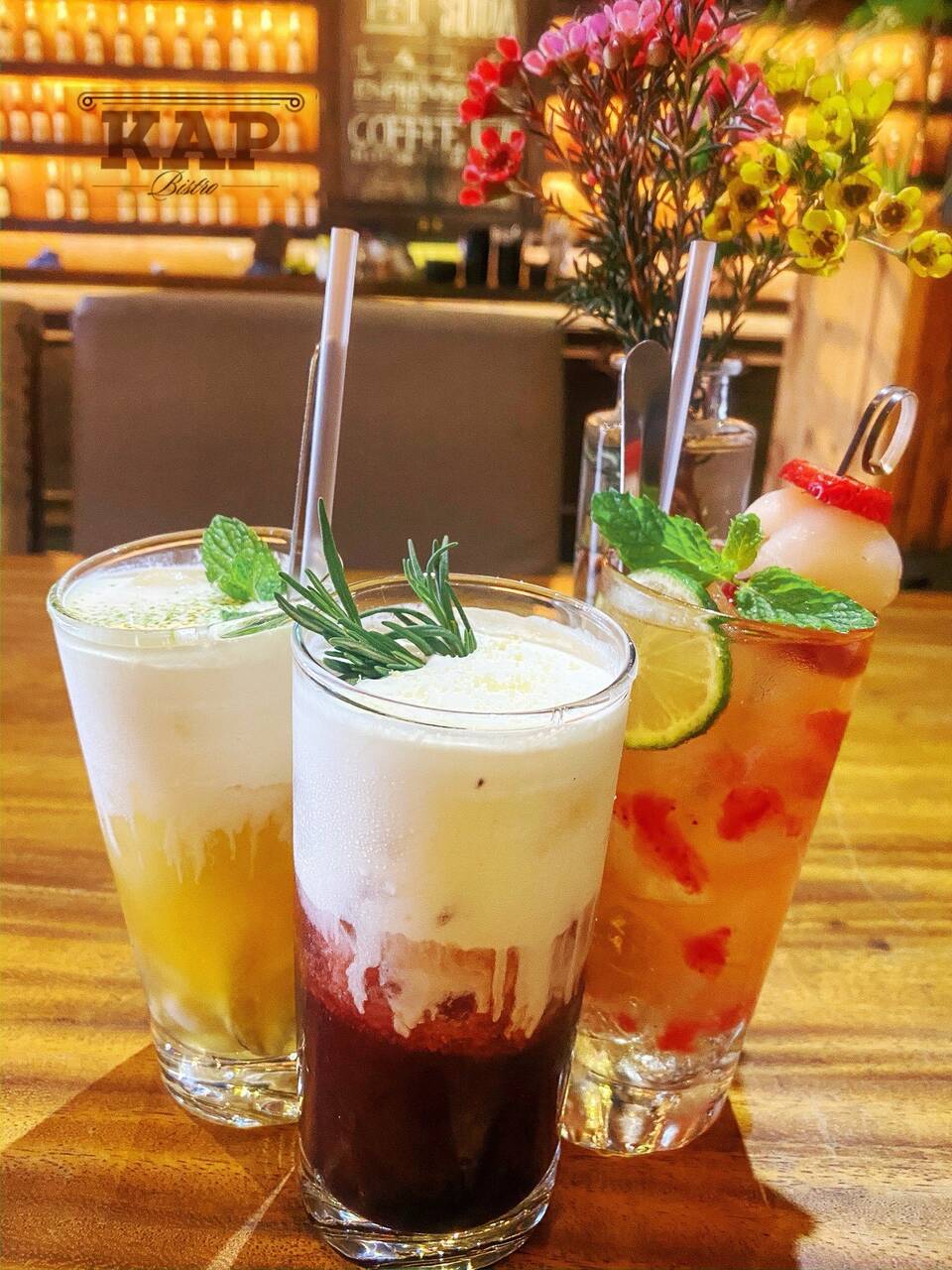 Ba ly đồ uống đặt trên quầy gỗ của KAP Bistro