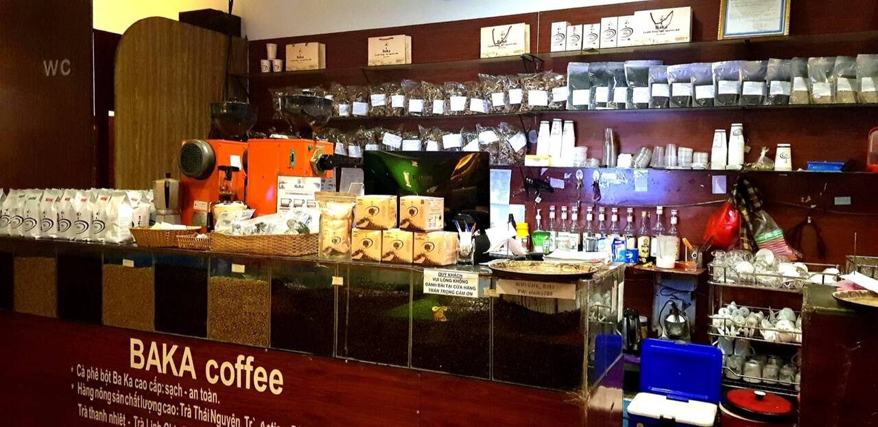 Quầy cà phê Baka với kệ bày túi và hũ cà phê phía sau