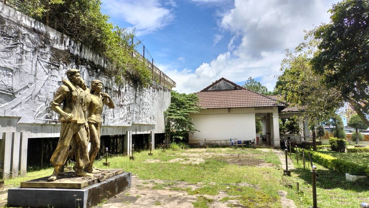 Bức phù điêu dài và tượng đồng hai người trong khuôn viên Nhà lao Pleiku