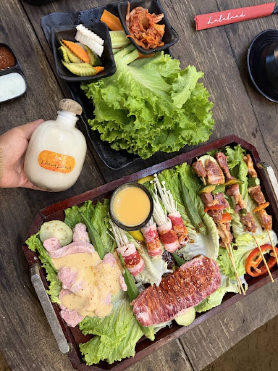 A grill set tray with beef, skewers, mushrooms wrapped in meat and lettuce at La La Land grill