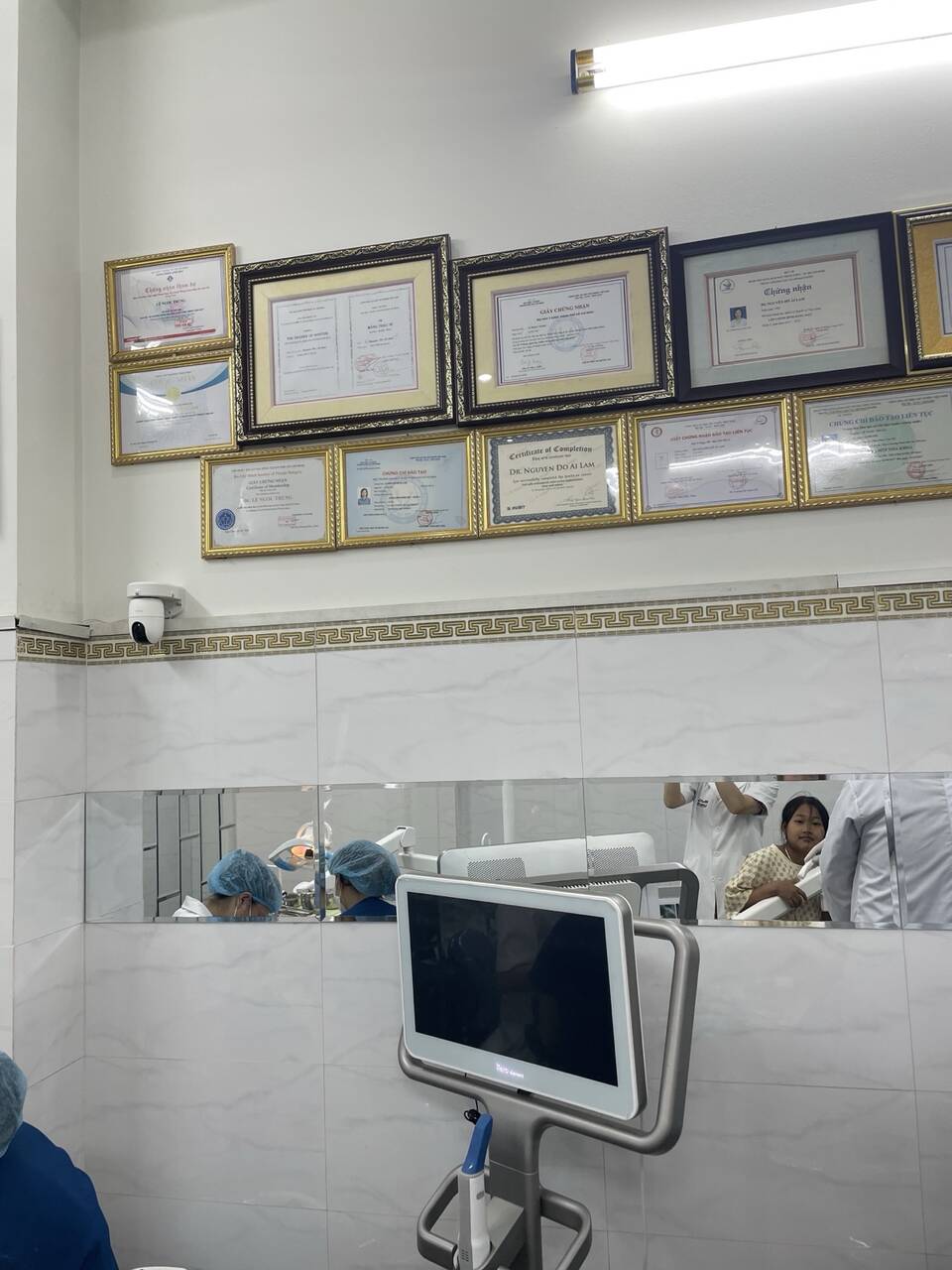 Tường treo chứng chỉ và màn hình máy quét ở Nha khoa Vạn Mỹ