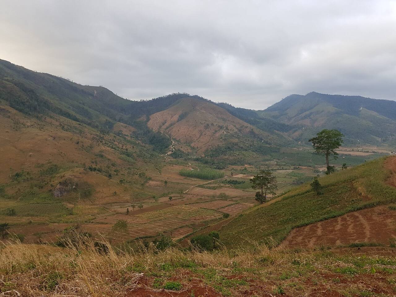Thung lũng và dãy núi nhìn từ sườn núi lửa Chư Đăng Ya dưới trời nhiều mây