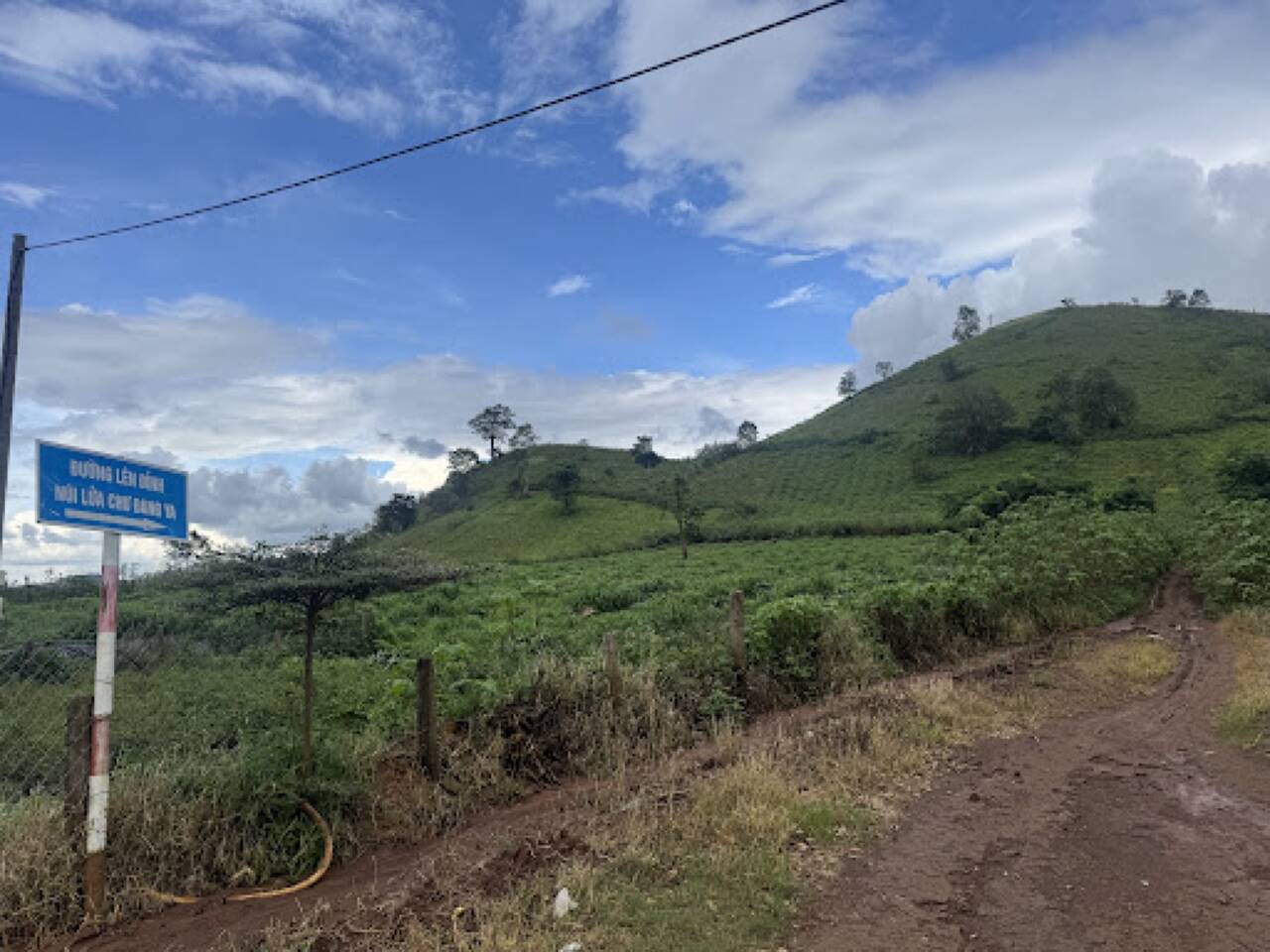 Biển chỉ đường lên đỉnh núi lửa Chư Đăng Ya và con đường đất đỏ lên đồi