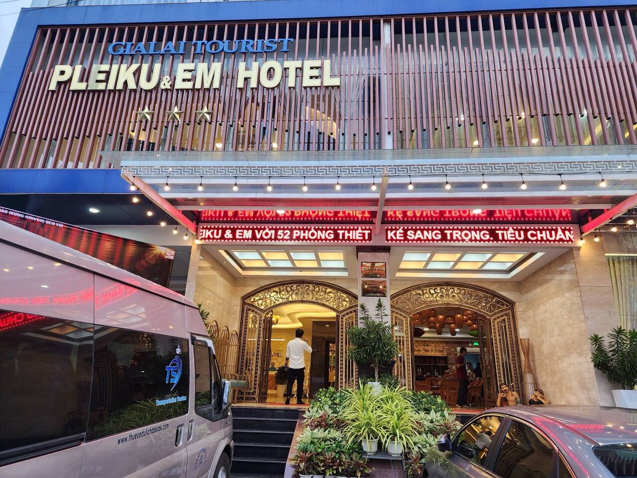 Mặt tiền Pleiku & Em Hotel với biển hiệu chữ lớn và bãi xe phía trước