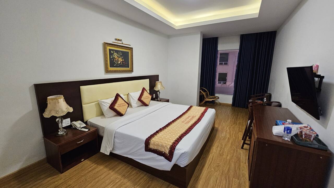 Phòng ngủ ở Pleiku & Em có sàn gỗ và tivi gắn tường
