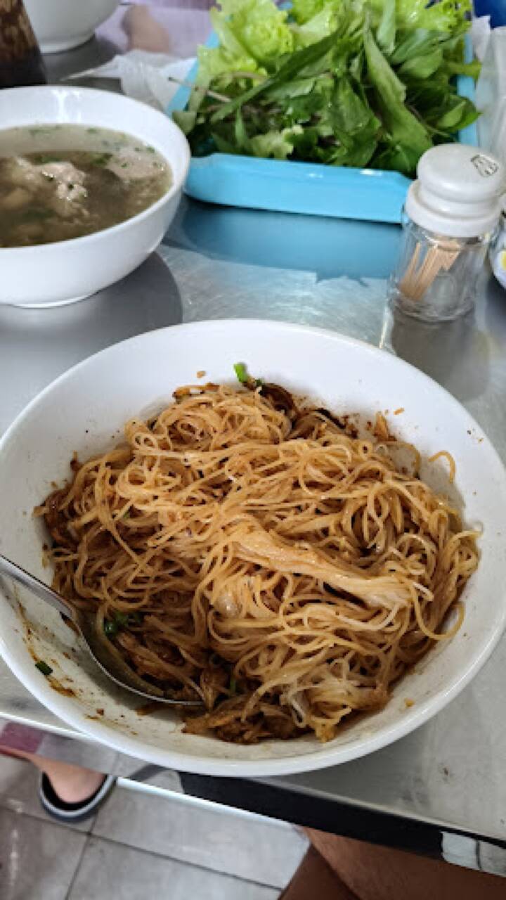 Bát phở khô trộn sốt và bát nước dùng có thịt, bò viên, hành lá tại Phở khô Bé Tư