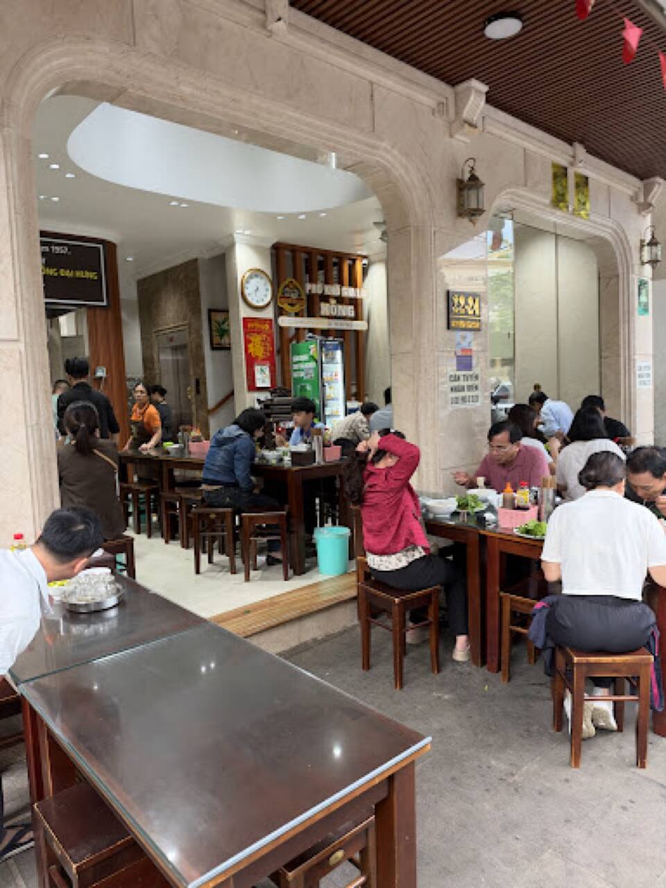 Mặt tiền quán Phở khô Hồng trên phố Nguyễn Văn Trỗi với bàn ghế và khách ngồi ăn