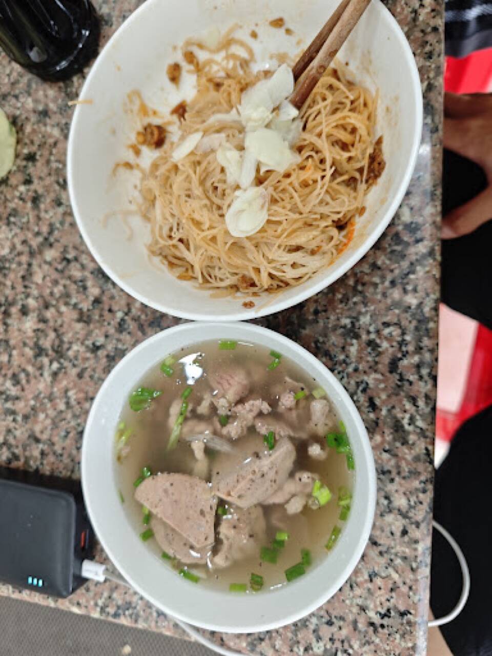 Bát phở khô trộn và bát nước dùng có thịt bò viên trên bàn tại Phở Khô Gia Lai - Hùng Ròm