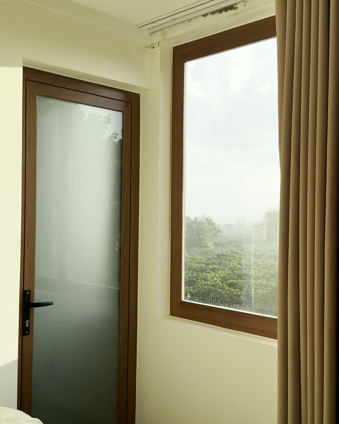 Phòng ngủ sáng màu với cửa sổ lớn nhìn ra đồi cà phê