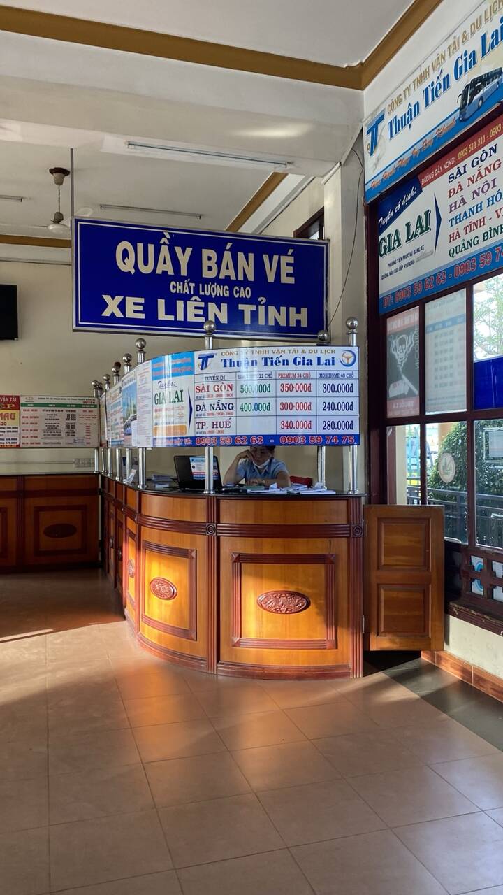 Quầy bán vé xe liên tỉnh trong bến xe Đức Long, có bảng giá dán trên quầy