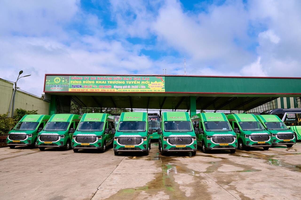 Dãy xe 16 chỗ màu xanh của nhà xe Đức Đạt đỗ thẳng hàng dưới mái che ở Pleiku